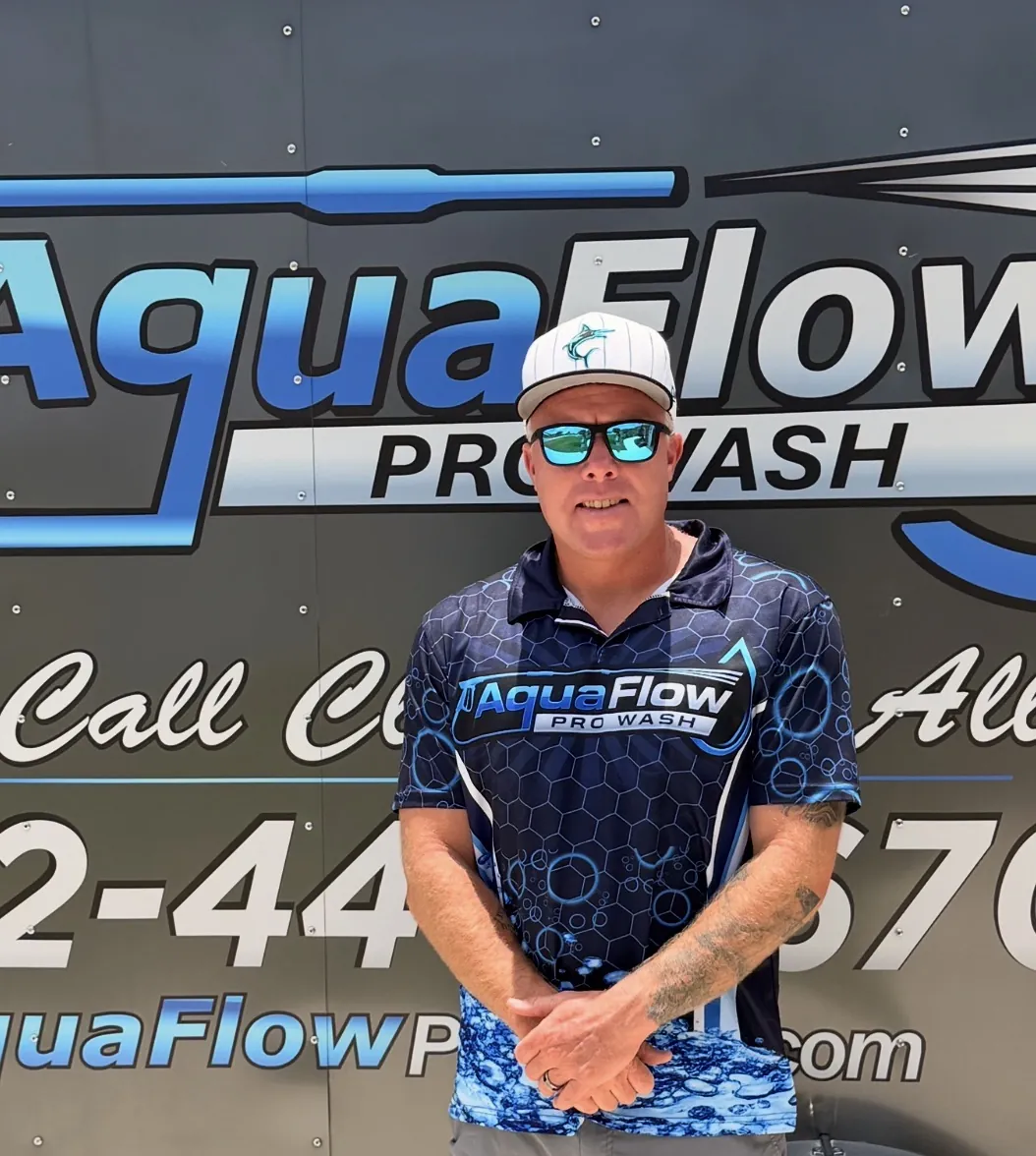 Adam, owner of AquaFlow Pro Wash, in front of the company trailer