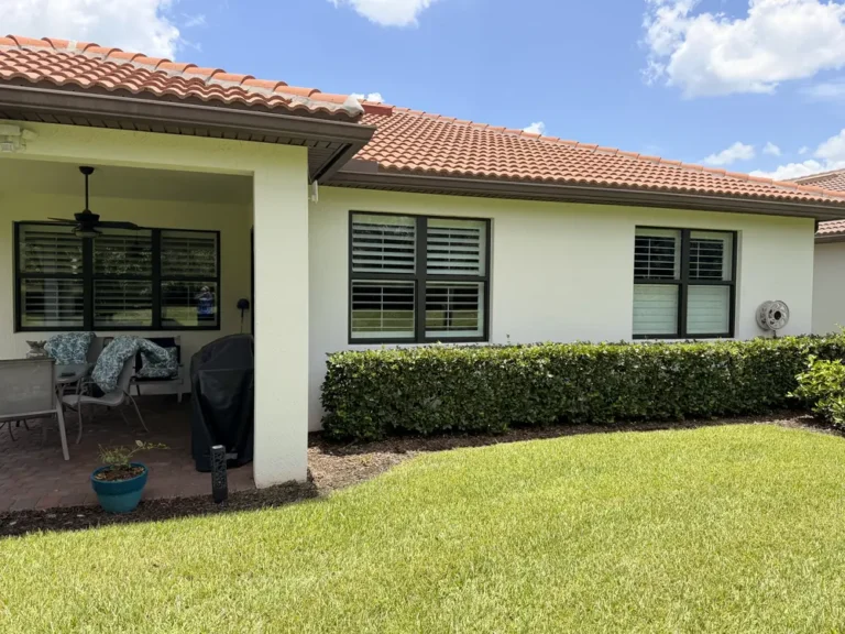 Clean stucco home with covered lanai and hedges in Port St. Lucie