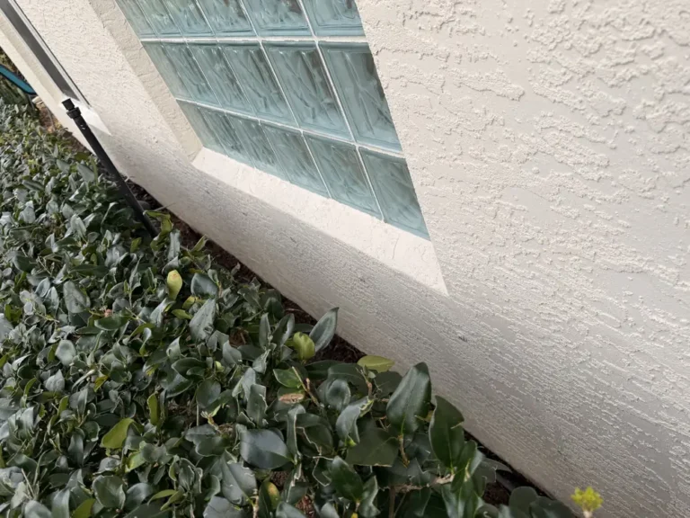 The same glass block window and stucco wall after house washing in Port St. Lucie