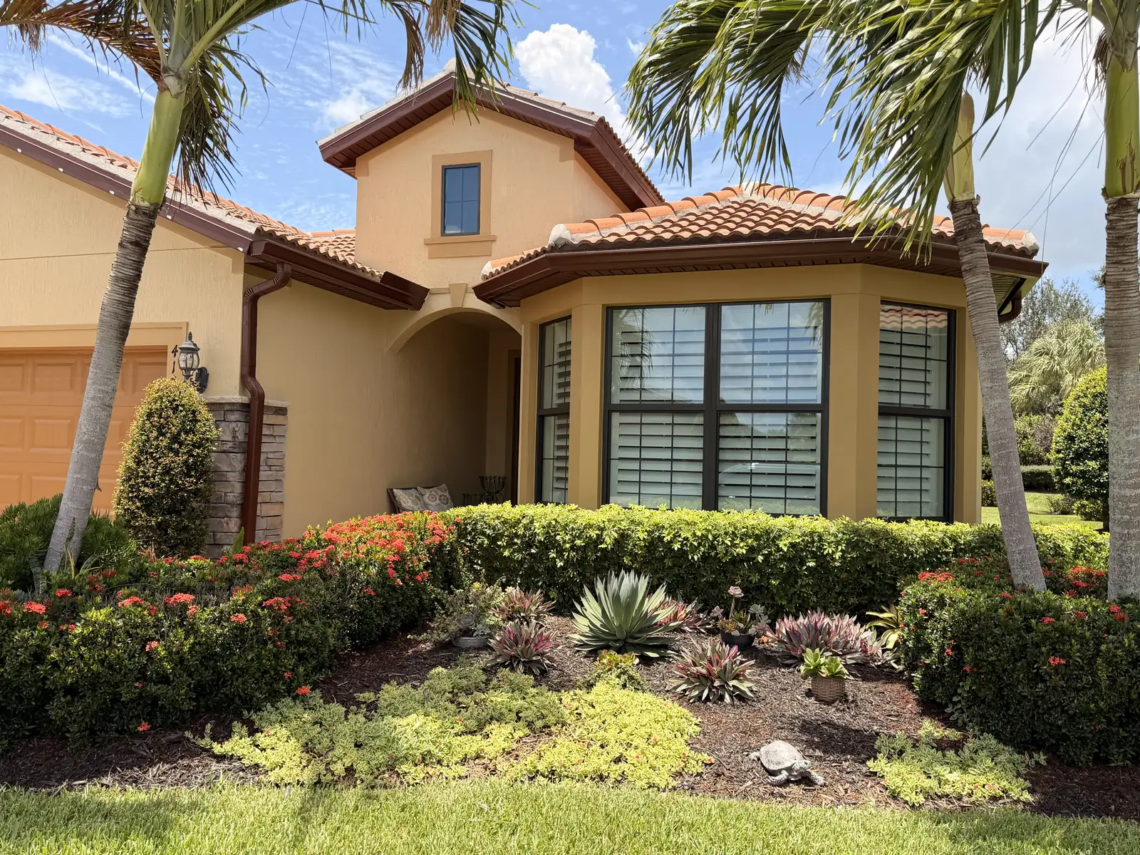 Stucco home with a tile roof and landscaping after an AquaFlow house wash in Port St. Lucie