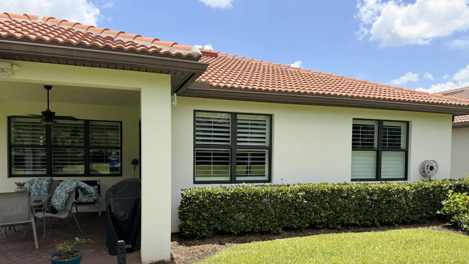 Clean stucco home with a tile roof, covered lanai and trimmed hedges in Port St. Lucie